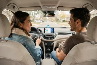 Deux passagers en covoiturage discutant dans une voiture moderne avec une application de covoiturage affichée sur un smartphone monté au tableau de bord