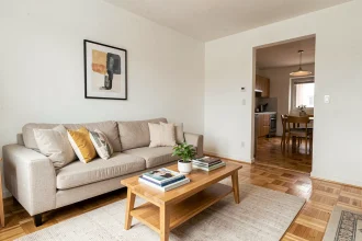 Salon familial relooké par le home staging avec canapé neutre, parquet chêne et décoration épurée dans un appartement familial à vendre